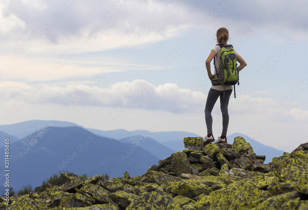 A woman on a mountain enjoying the view and the feeling of space. Woman on a mountain enjoying the view.